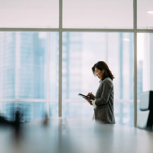 Businesswoman working on a tablet, indicating digital accessibility and online finance consultancy options.